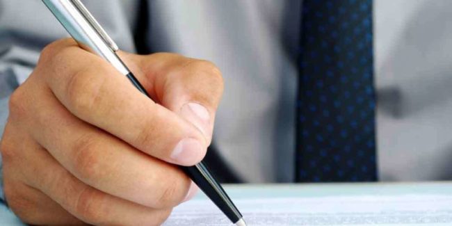 A hand of a man and pen on a piece of paper